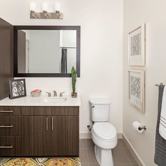 Fuse Cambridge Apartments - bathroom with tile flooring, dark cabinetry, and white countertops