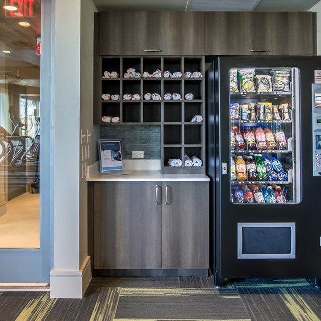 Fuse Cambridge Apartments - refreshment bar in fitness center with towels, snacks, and drinks