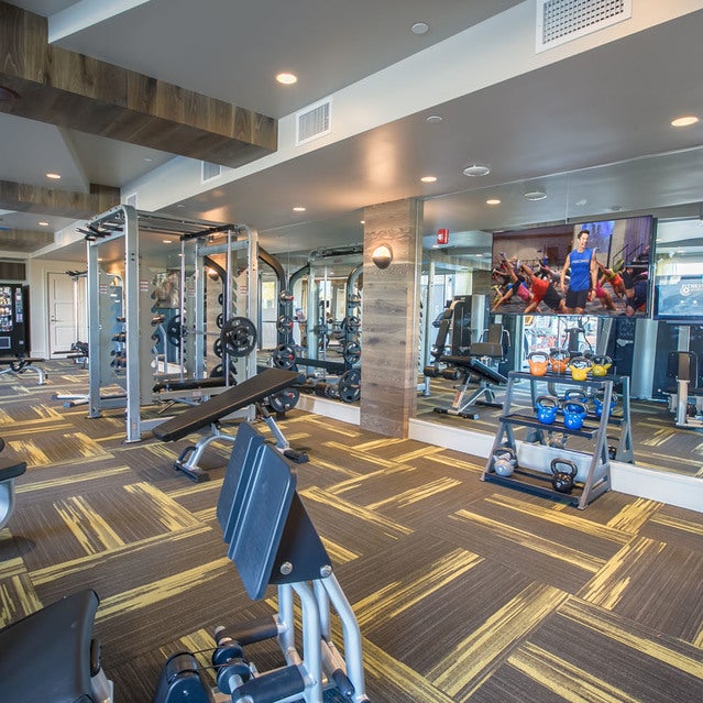 Fuse Cambridge Apartments - fitness center with weight lifting machines, kettlebells, medicine balls, and more